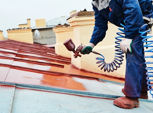 Spraying protective coating on a metal roof