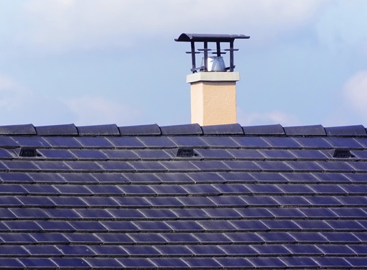 Roof with blue shingles and a chimney