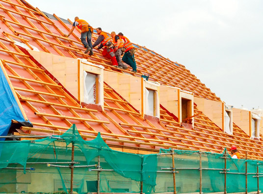 Three roofers working on an orange roof