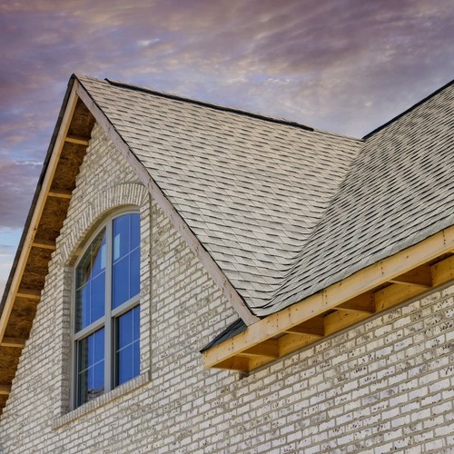 brick home with an asphalt shingle roof