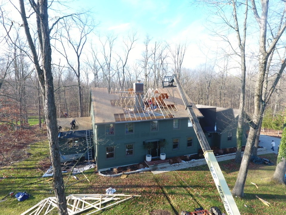 Expert Plain City residential roofing replacement on a two-story home with dark asphalt shingles and blue siding.