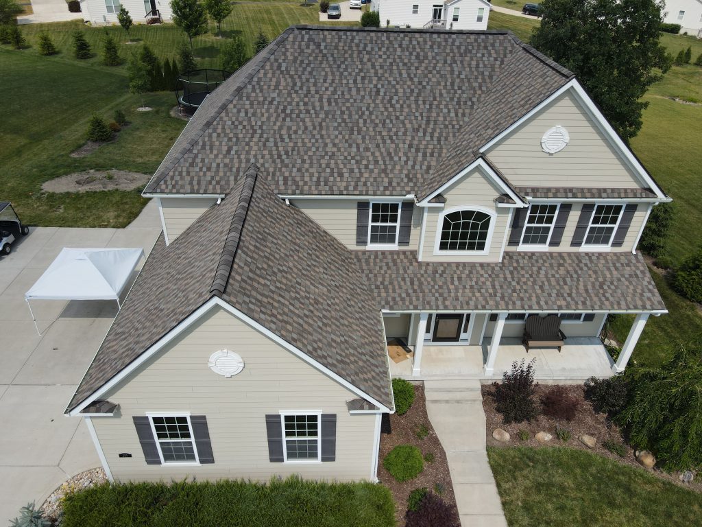 Aerial view of a tan two-storey home with a brown and grey blended shingle roof