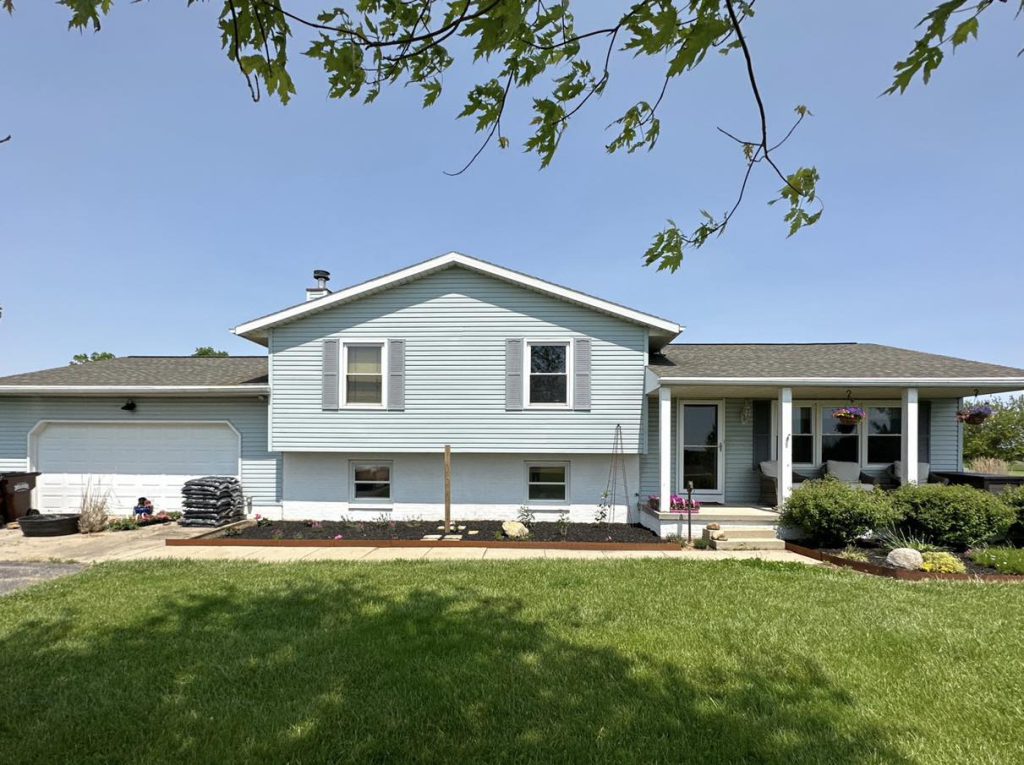 Light blue ranch home with new siding and a manicured lawn