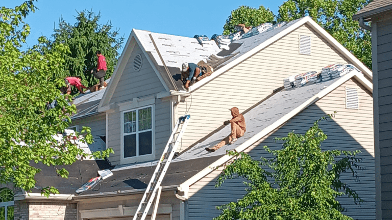 Kerrigan crew on ladders working on a blue-sided home