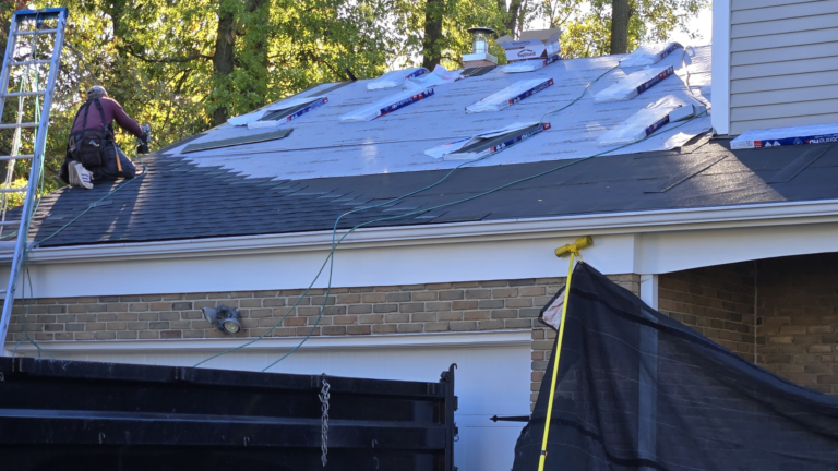 Blue underlayment laid over a garage roof mid-installation