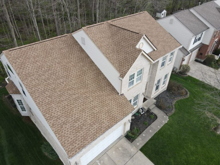 Aerial view of a new tan shingle roof on a two-storey home