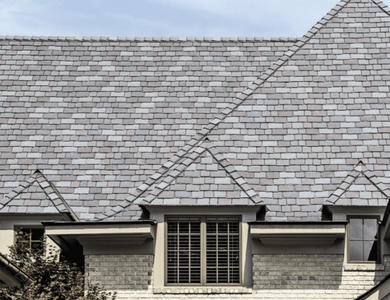 Close-up of grey composite slate tiles on a roof with dormer windows