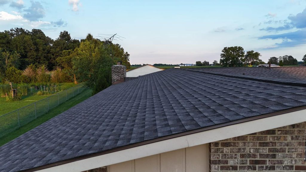 Dark architectural shingle roof against an evening sky