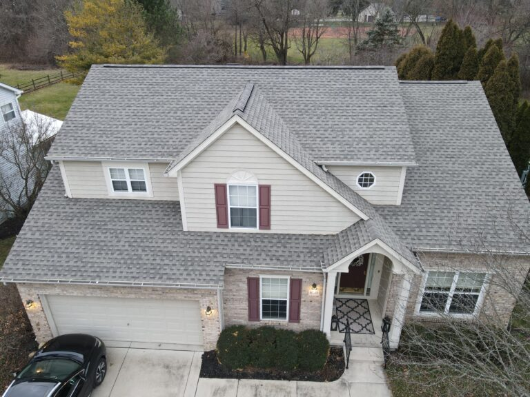 Aerial view of a cream two-storey home with a light grey shingle roof