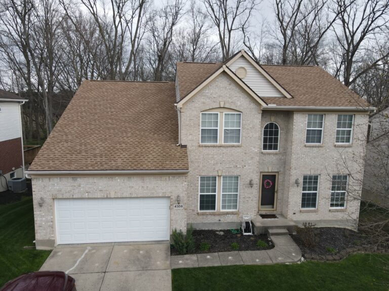 Aerial view of a brick two-storey home with a new tan shingle roof