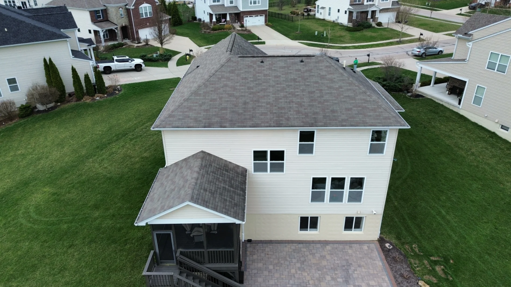 Aerial view of a two-storey cream-sided home with a new grey shingle roof