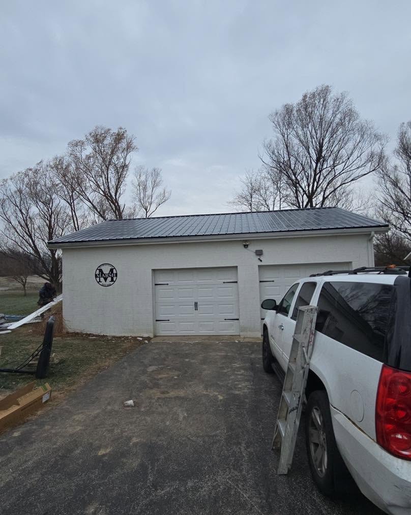 Detached garage finished with a black standing seam metal roof