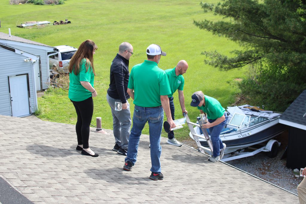 Kerrigan crew in green shirts unloading materials on a driveway