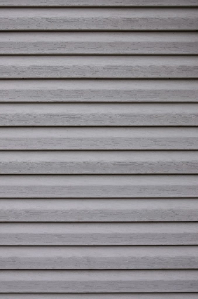 Close-up of pale grey vinyl lap siding panels