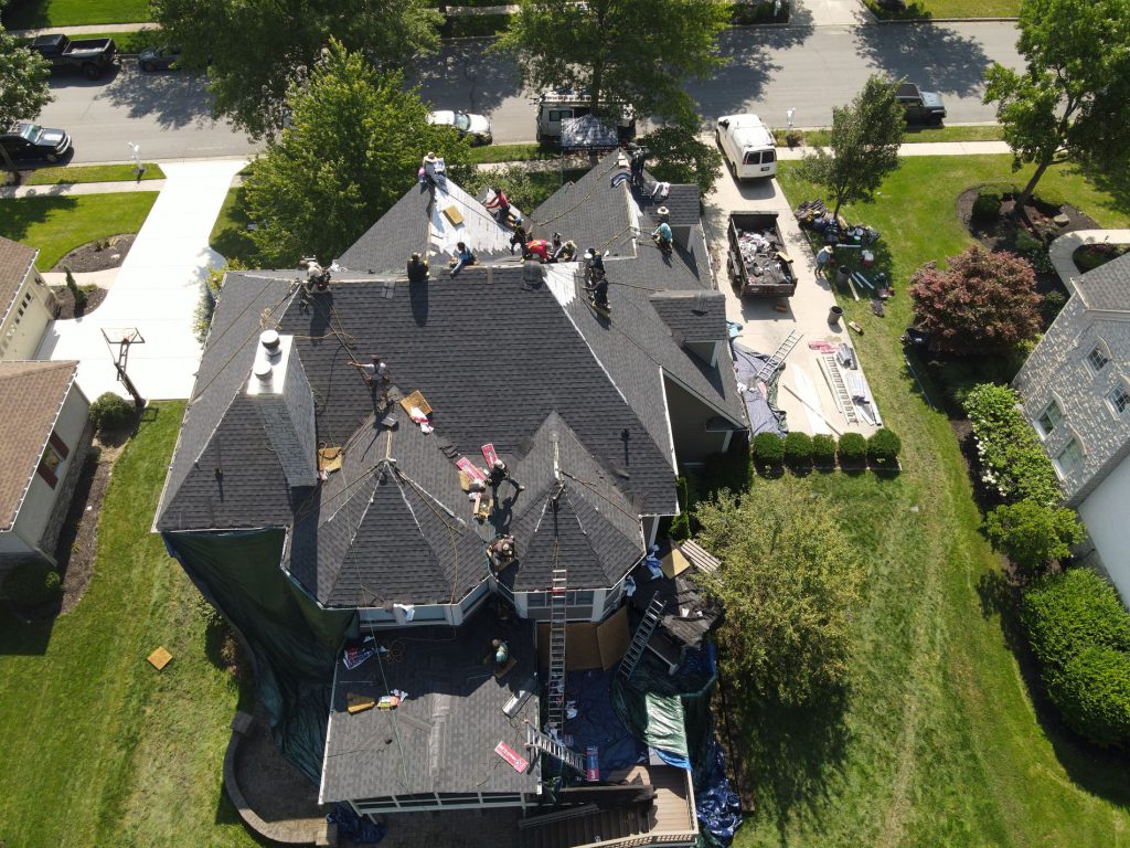Aerial view of a large home with a Kerrigan crew and vehicles on site
