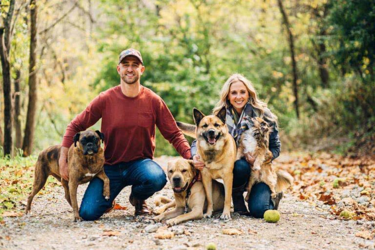 Aaron Kerrigan and family with their dogs on a wooded autumn trail