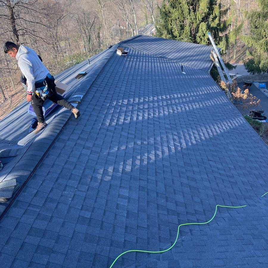 Kerrigan roofer installing shingles along a roof ridge