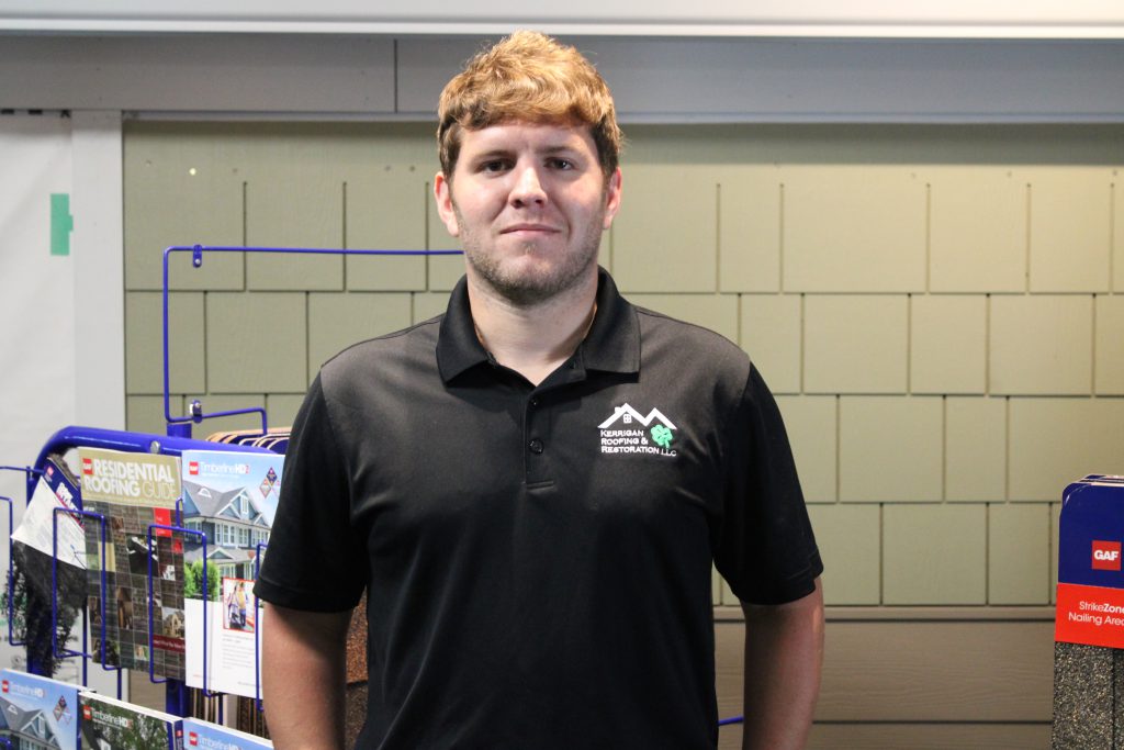 Tyler Larson, Production Manager, in a black Kerrigan Roofing polo