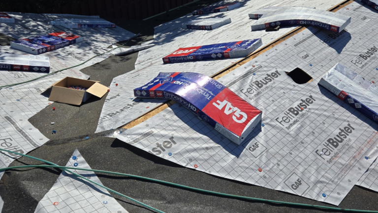 GAF FeltBuster underlayment and Timberline shingle bundles laid across a roof deck