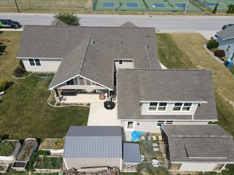 Aerial view of a ranch home and outbuilding with new roofs