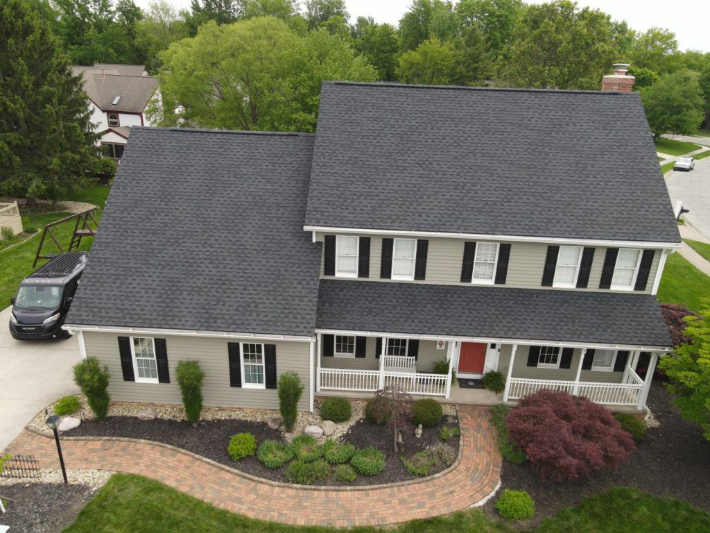 Aerial view of a two-storey colonial home with a new dark grey shingle roof