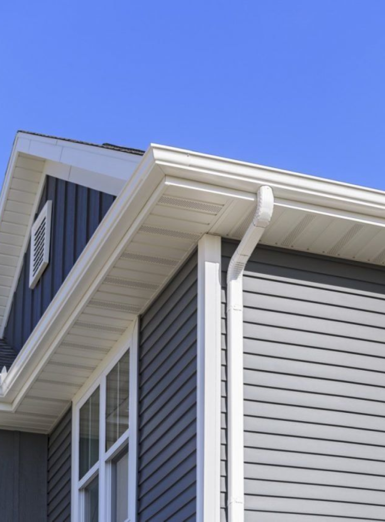 White seamless gutter and downspout on navy blue siding