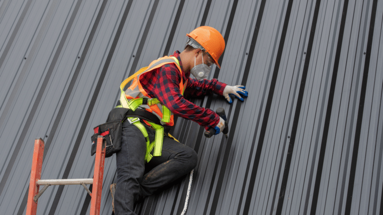 Roofer in a hard hat fixing standing seam metal panels