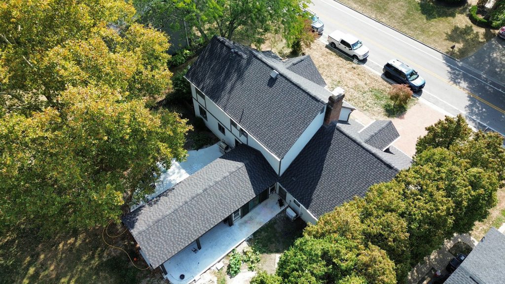 Aerial view of a finished dark shingle roof on a family home