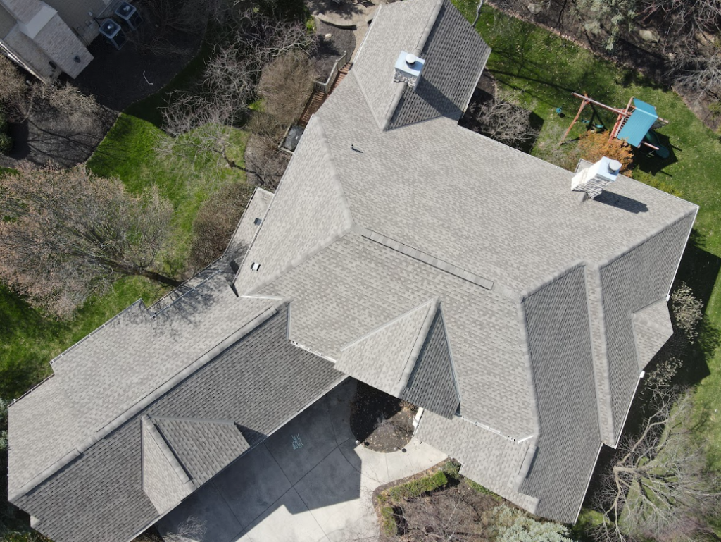 Aerial view of a complete asphalt shingle roof system on a family home
