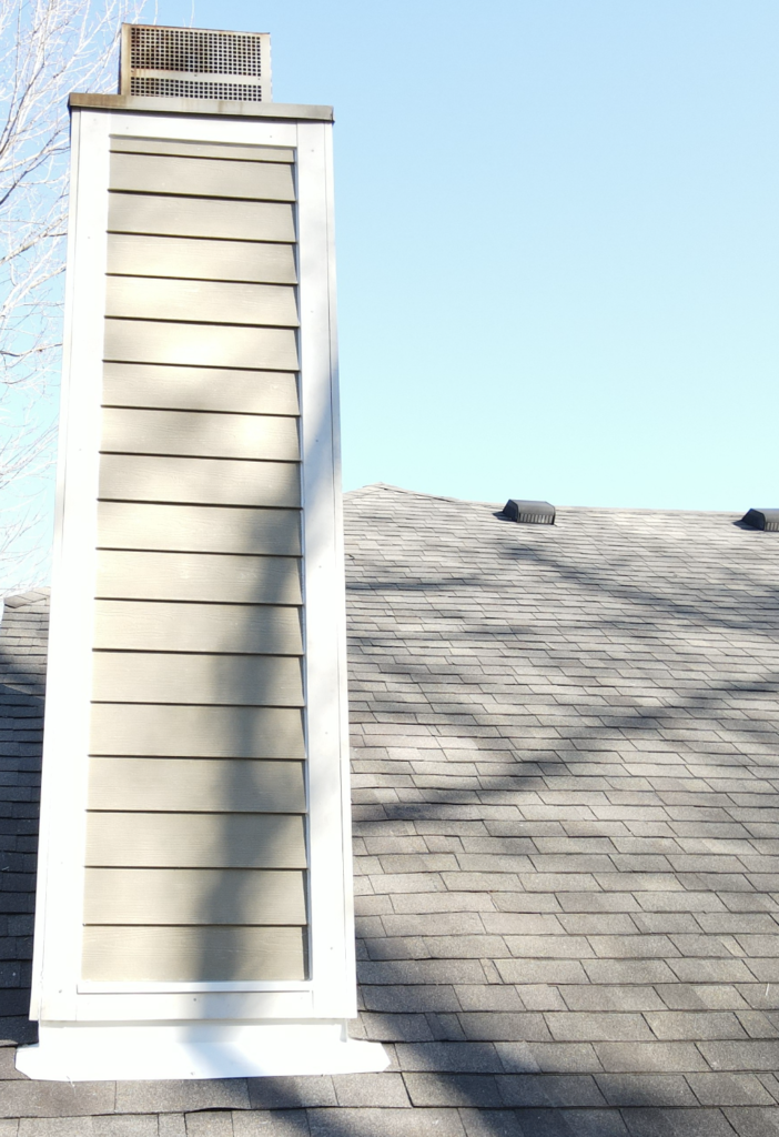 Close-up of cream James Hardie lap siding meeting a grey shingle roof